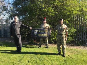 Major Curran is welcomed at the end of the walk by members of his unit