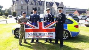 Sub Lieutenant Duffield-Smith with colleagues holding Armed Forces Day flag