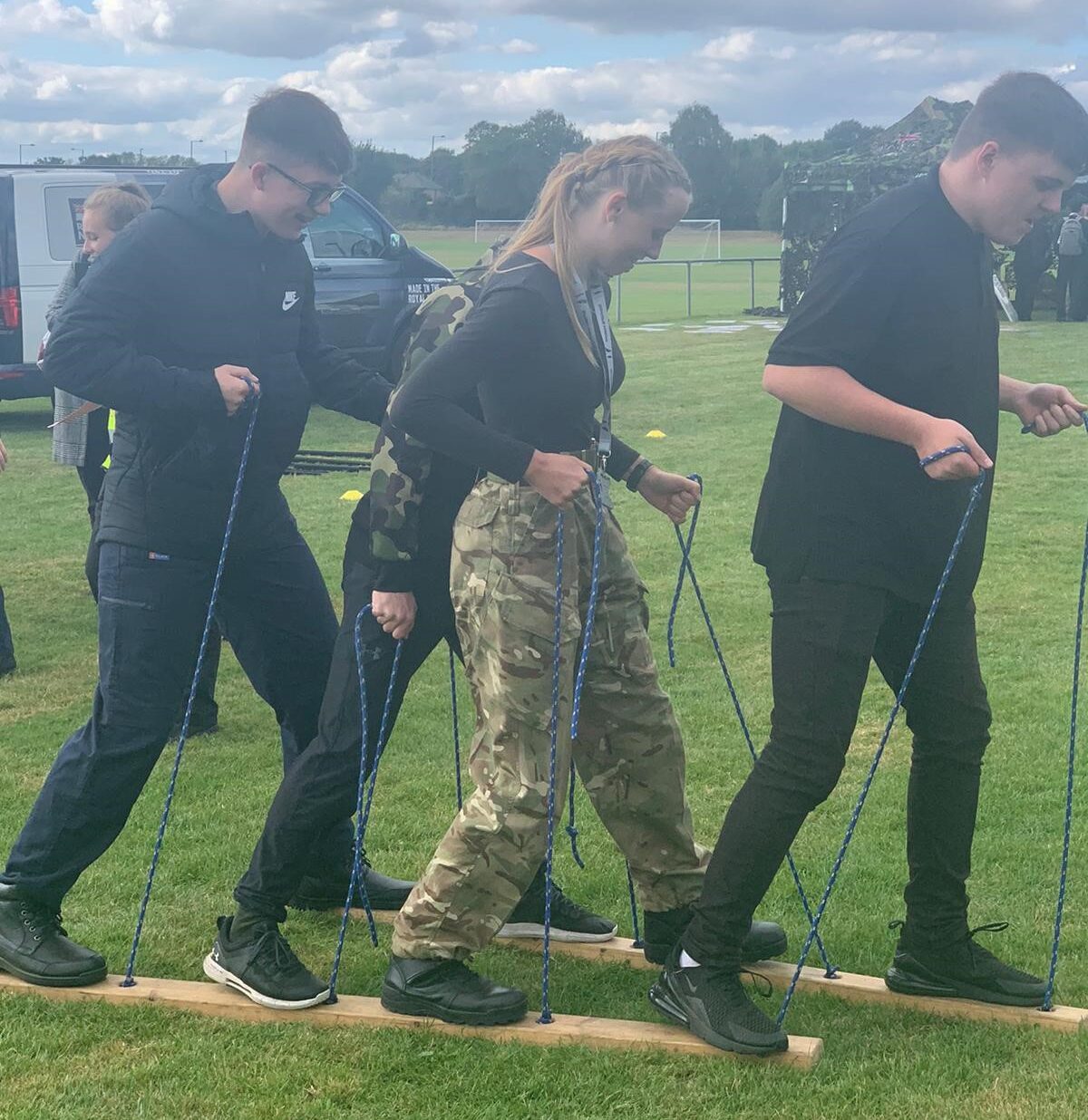 Students at the DRIVE initiative community event take part in a practical teamwork activity using ropes and planks, to move forward together