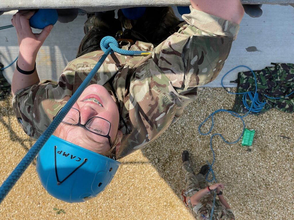 An Army Cadet from Hereford & Worcester ACF smiles as she reaches the top of the climbing wall