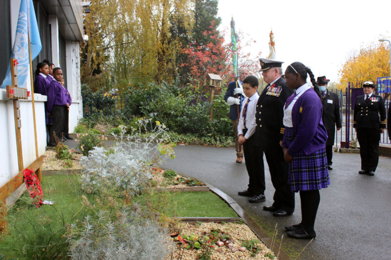 Students from King Solomon International Business School lay a wreath at their Remembrance Garden, alongside members of the Navy