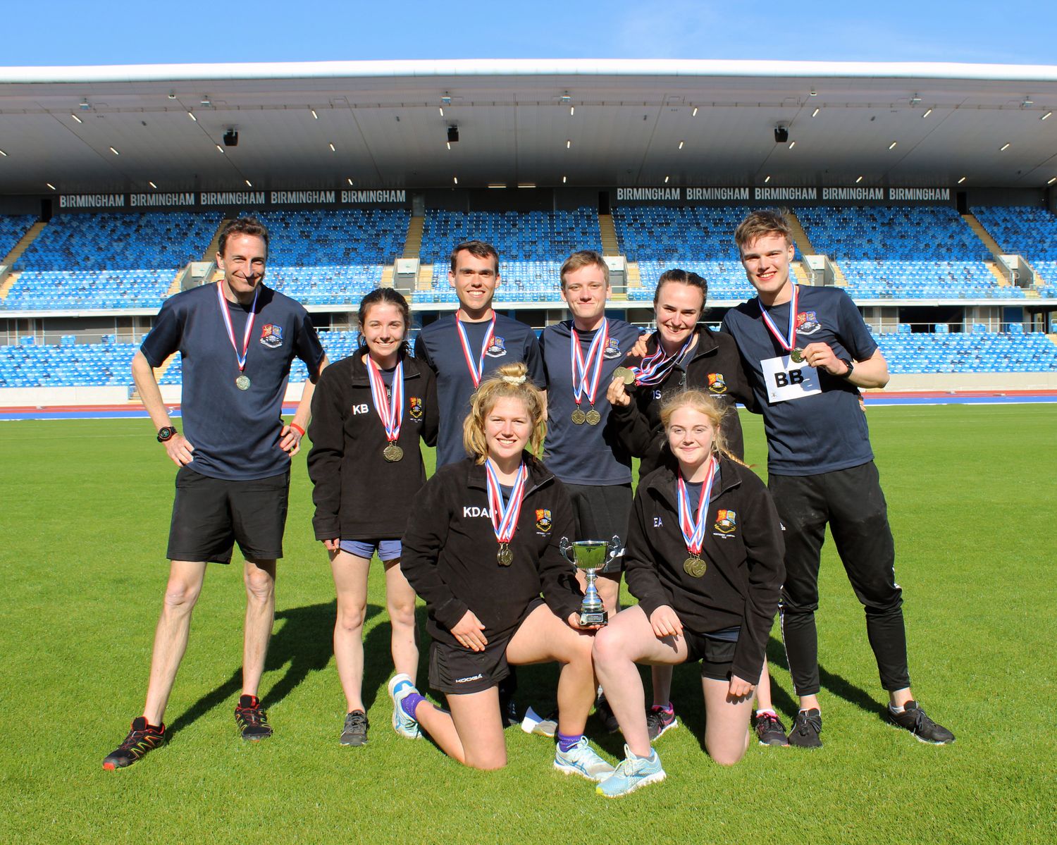 The BUOTC team pose smiling with their winning trophy and medals in front of the new Alexander Stadium stand, at the Midlands Army Athletics Championships.