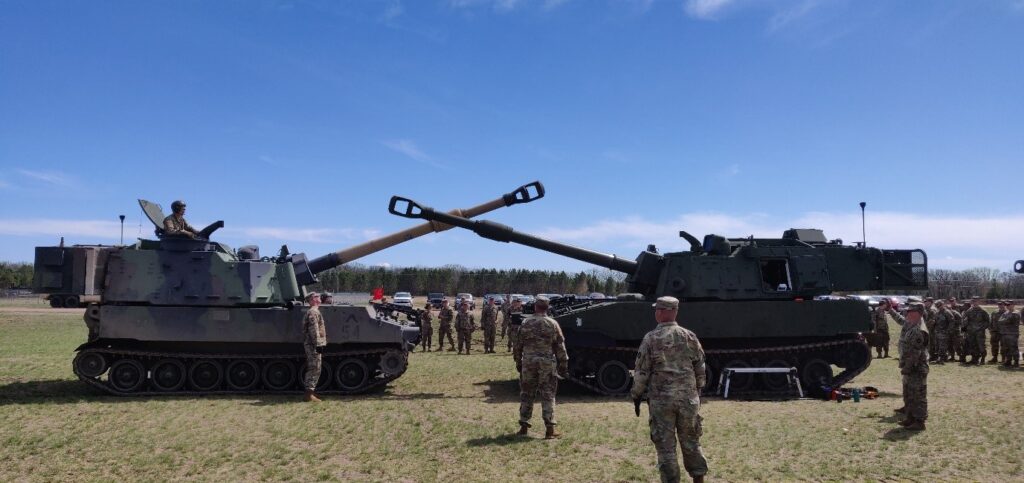 Members of the unit by two tanks.