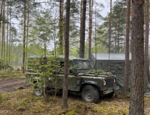 Land Rover by forest base.