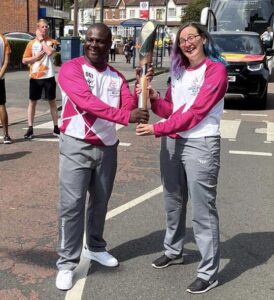 PO Grandison holding the baton with another relay runner