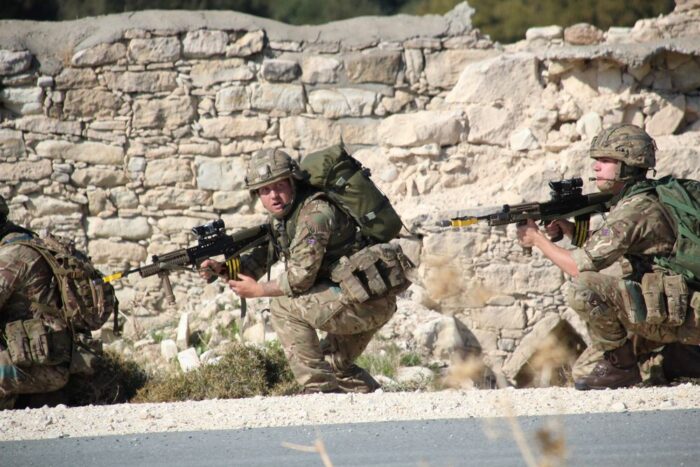 Two Reservists in combat uniforms are crouching with their guns mid-exercise on Exercise Kronos Hunter.