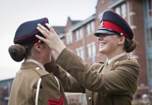 Two female soldiers getting ready for a parade.