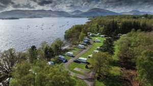 The Millarochy Bay campsite aerial view with a lake and mountains.