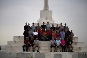 All soldiers sat together by large stone memorial monument.