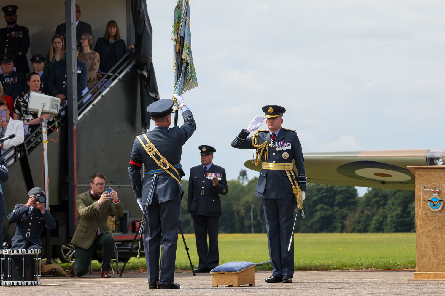 A Reservist from 605 Squadron holds up the new Standard and salutes the reviewing Officer.