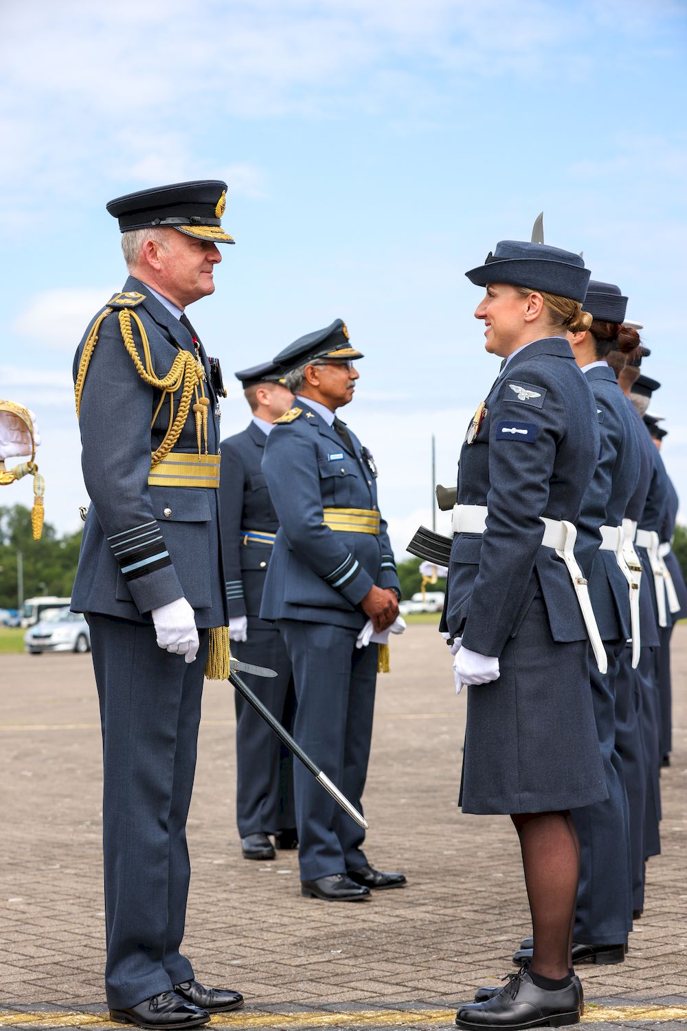 The parade's reviewing Officer is smiling and talking to members of the RAF who are on parade in their uniforms. 