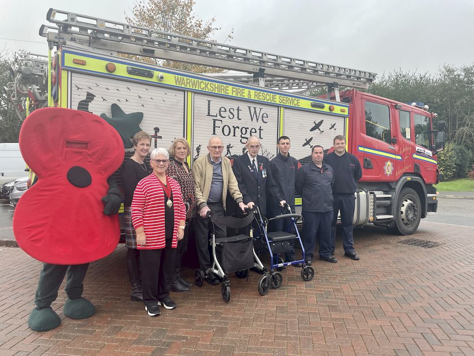 Residents and guests at Galanos House stand in front of Warwickshire Fire and Rescue Service's fire truck with a 'Lest we Forget' mural painted on the side of its shutters. The care home is accredited as veteran friendly.