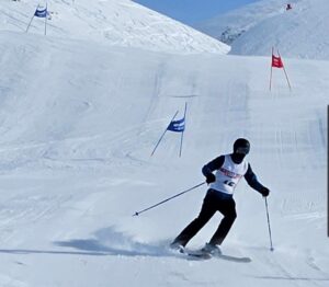 Single skier coming down a slope.