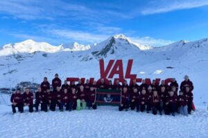 Group photograph of all personnel with a snowy mountain range in the background.