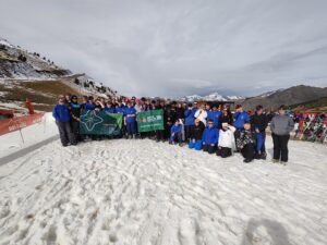 Group photograph on a mountain with a mountain view behind.