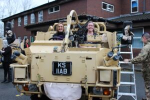 Two employers in a military vehicle.