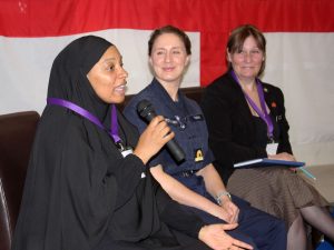 Vanessa, from 2 Much Passion CIC, shares her thoughts and experiences with the audience and the rest of the panel. She is sitting down facing the audience and speaking into a microphone.