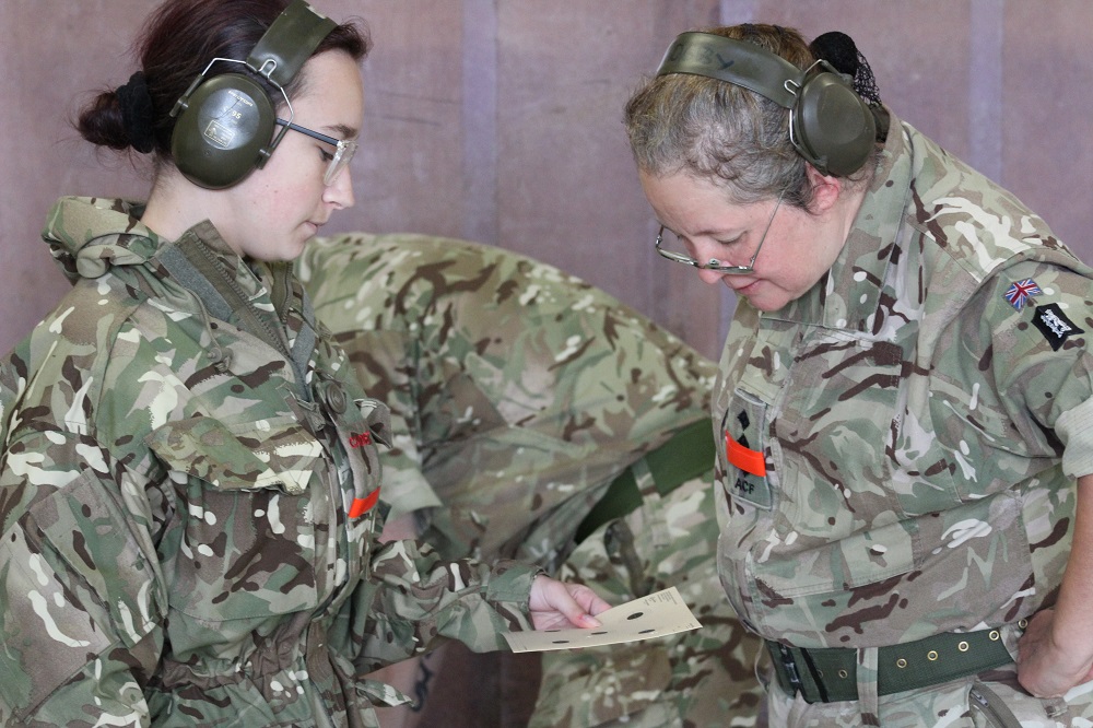 Adult Volunteers review a Cadet's target practice card.
