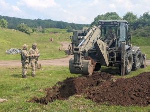 Military plant engineer training. Using a digger to dig trenches.