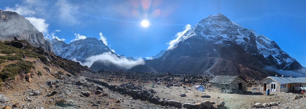 Panoramic view of mountain peaks, blue sky and sunshine.