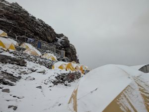 Snow covered tents high up in the mountains.
