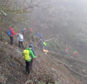 Reservists descending down rough mountain terrain.
