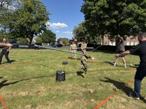 Participants taking part in a team task, holding poles and ropes.