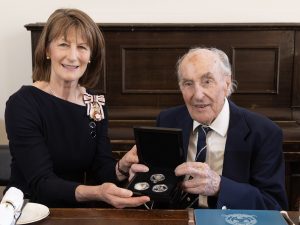 The Lord-Lieutenant of Shropshire and Colin holding the commemorative VE Day coins.