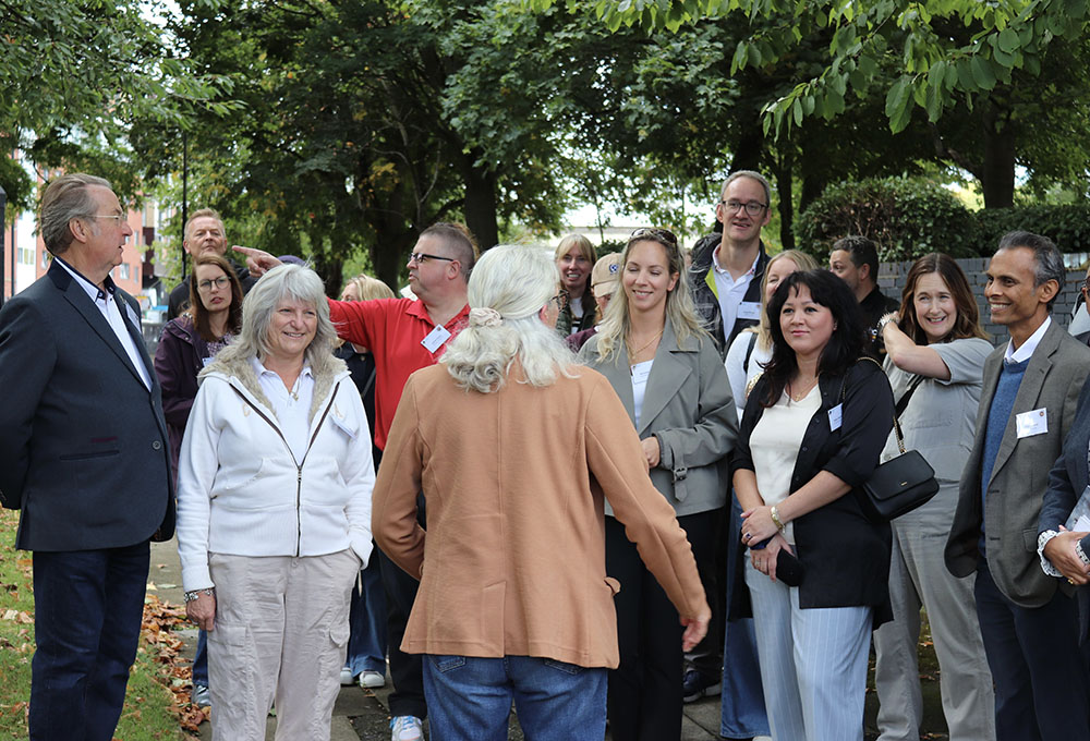 A group of local businesses are listening intently to city walking guide, Verity, as she points out local landmarks on the netwalking event.